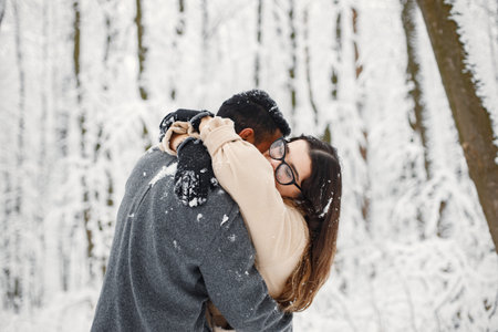 Portrait of a romantic couple spending time together in winter forestの写真素材