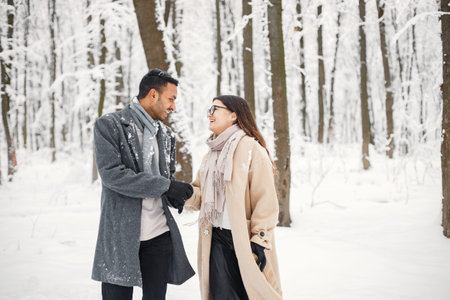 Portrait of a romantic couple spending time together in winter forest