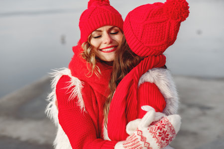 Mother and child in knitted winter hats play in winter parkの写真素材