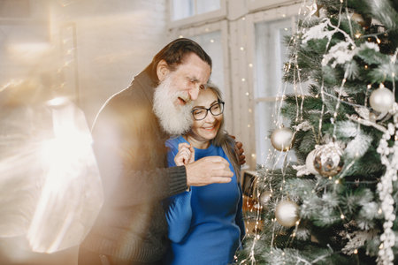 Senior couple with gifts near the Christmas treeの写真素材