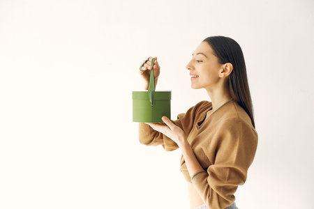 Beautiful girl standing in a studio with presents
