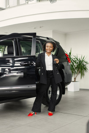 Portrait of black female driver standing near a carの写真素材