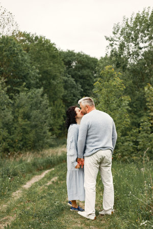 Senior couple kissing and walking in a autumn parkの写真素材