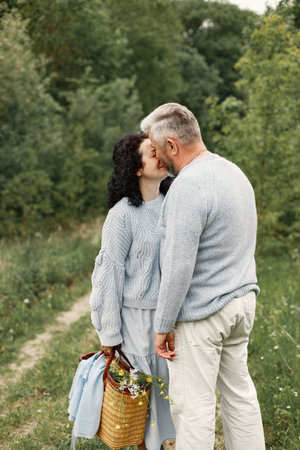 Senior couple kissing and walking in a autumn parkの写真素材