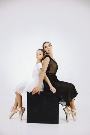 Mother and daughter ballet dancers against white backgroundの写真素材