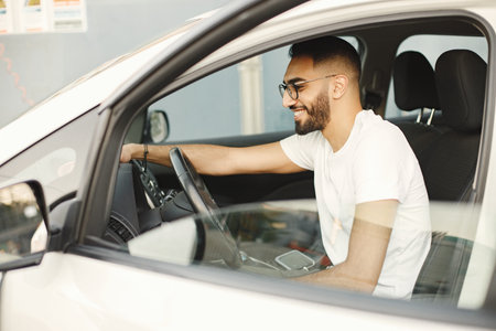 Indian man polishing inside his white car with a rug