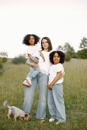 Caucasian mother embracing her mixed race daughtersの写真素材