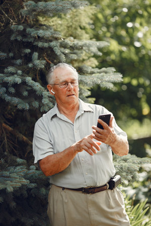 Portrait of happy handsome older man using smartphoneの写真素材