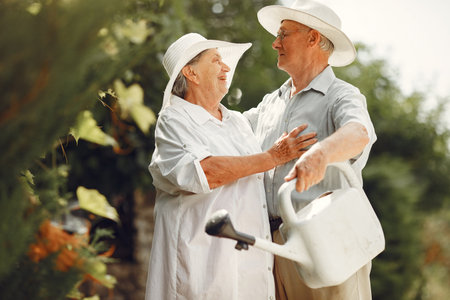 Beautiful old couple spend time in a summer gardenの写真素材