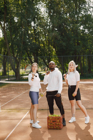 Two women and black race trainer at tennis courtの写真素材