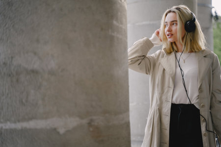 Blonde listen music in a summer cityの写真素材