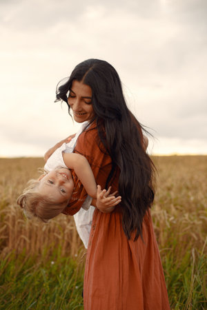 Mother with little daugher playing in a summer fieldの写真素材