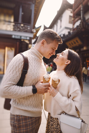 newlywed couple eating ice cream from a cone on a street in Shanghai near Yuyuan China.の写真素材