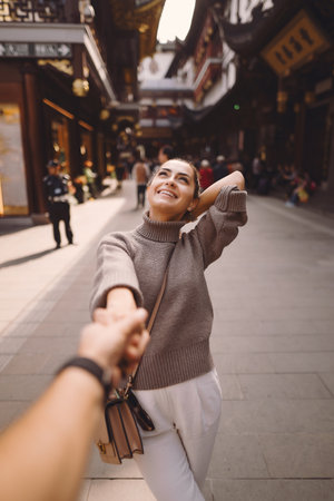 newlywed couple showing affection and holding hands in Shanghai near Yuyuan.の写真素材