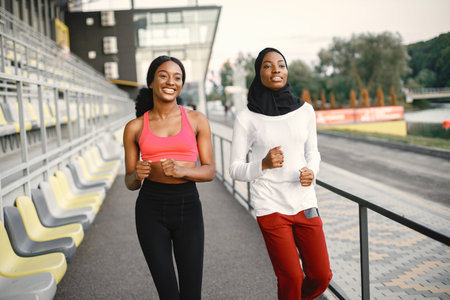 Two black women running on a stadiumの写真素材