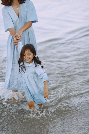 Mother with daughter playing in the little riverの写真素材