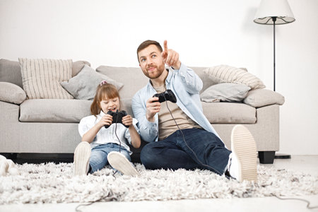 Girl with Down syndrome and her father sitting on a floor and playingの写真素材