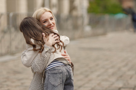 Girl hugging her nother with a flag of Ukraine on a cheekの写真素材