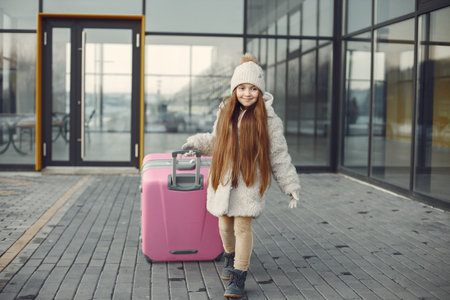Portrait of a little girl with luggage going from airportの写真素材