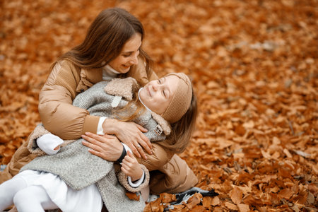 Mother and her daughter hugging in autumn forestの写真素材