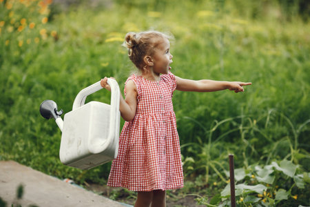 young girl watering vegetable at the rural farmの写真素材