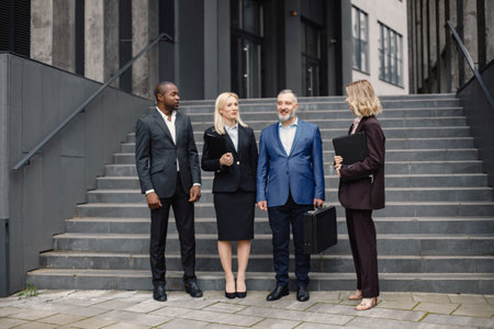 Business people standing and talk to each other in front of modern officeの写真素材