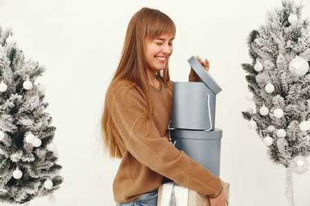 Beautiful girl standing in a studio with presents