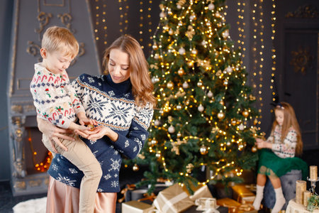 Mom and two her children decorating Christmas treeの写真素材