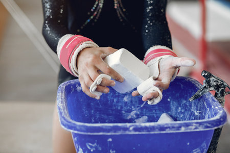 Midsection of a female gymnast applying white powder to handsの写真素材