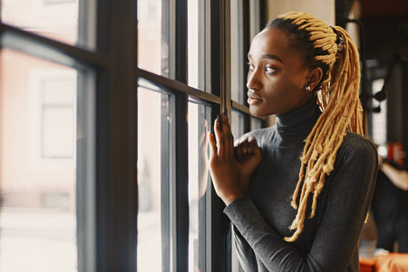 African woman standing by the windowの写真素材