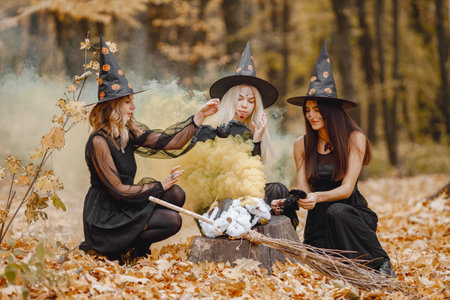 Three witches in forest on Halloween make magic potionの写真素材