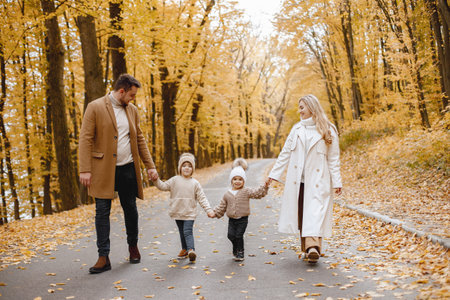 Beautiful young family on a walk in autumn forest
