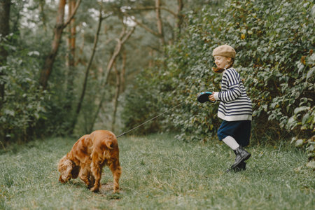 Little girl walks in autumn forest with a dogの写真素材