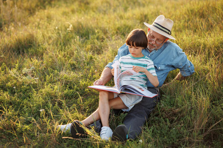 Little boy with his grandfather in a field at summerの写真素材