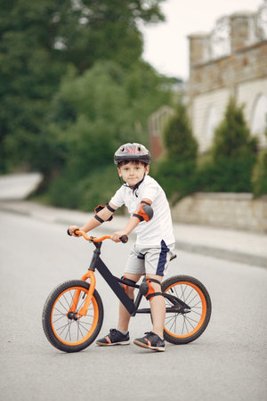 Boy in a helmet riding bike in a summer parkの写真素材