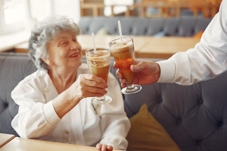Beautiful old couple sitting in a cafeの写真素材