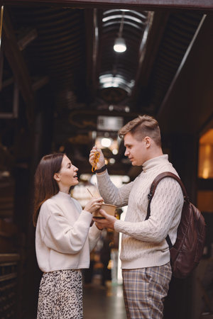 newlywed couple eating noodles with chopsticks in Shanghai outside a food market