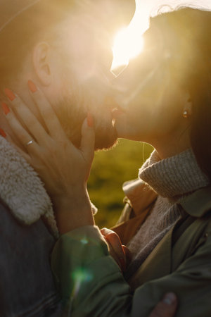 Stylish romantic couple walking in a field and posing for a photoの写真素材