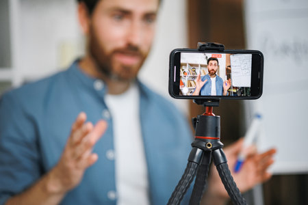 Focus on a phone screen recording a man tutor explaining rules of foreign languageの写真素材