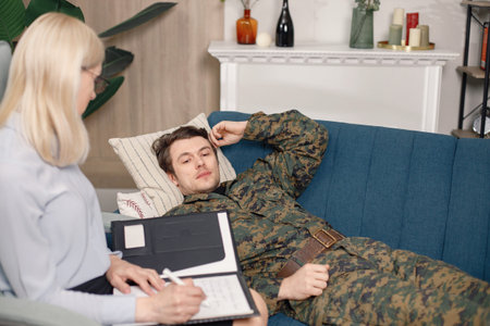 Soldier in military uniform talking to psychiatrist at therapy session
