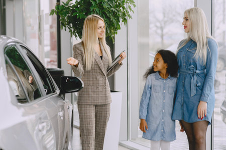 Caucasian mother with african daughter in a car salonの写真素材