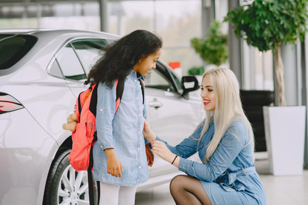 Caucasian mother with african daughter in a car salonの写真素材