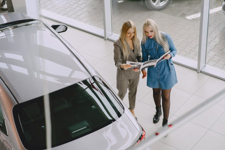Stylish and elegant women in a car salonの写真素材
