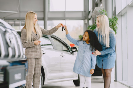 Caucasian mother with african daughter in a car salonの写真素材