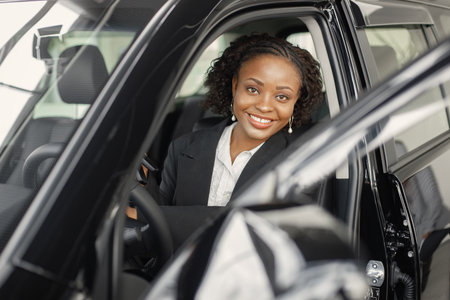 Portrait of black female driver in a car wearing black costumeの写真素材
