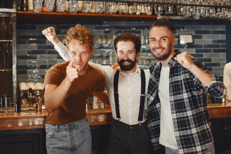 Three men are standing at the bar.の写真素材