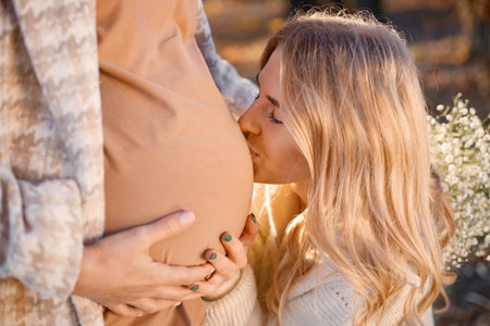 Portrait of curly blonde woman near a pregnant belly