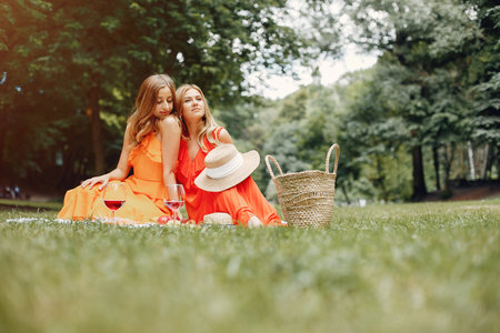 Elegant and stylish girls in a summer parkの写真素材