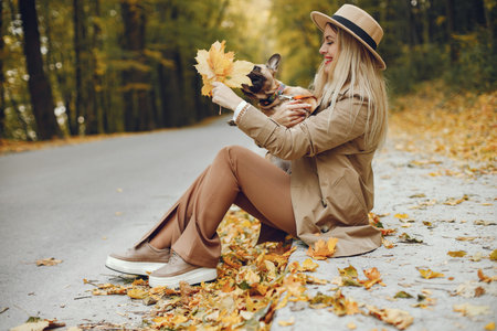 Portrait of a young blonde girl with a little puppy french bulldogの写真素材