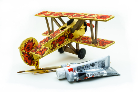 Toy airplane painted in khokhloma style, acrylic paints and brushes on white backgroundの写真素材
